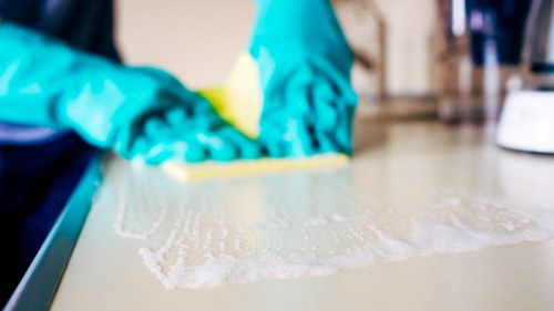 Cleaner dusting a living room in W14 during a one off clean